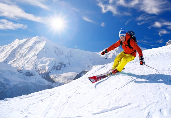 Skier skiing downhill against Matterhorn peak in Switzerland