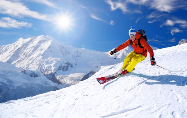 Skier skiing downhill against Matterhorn peak in Switzerland