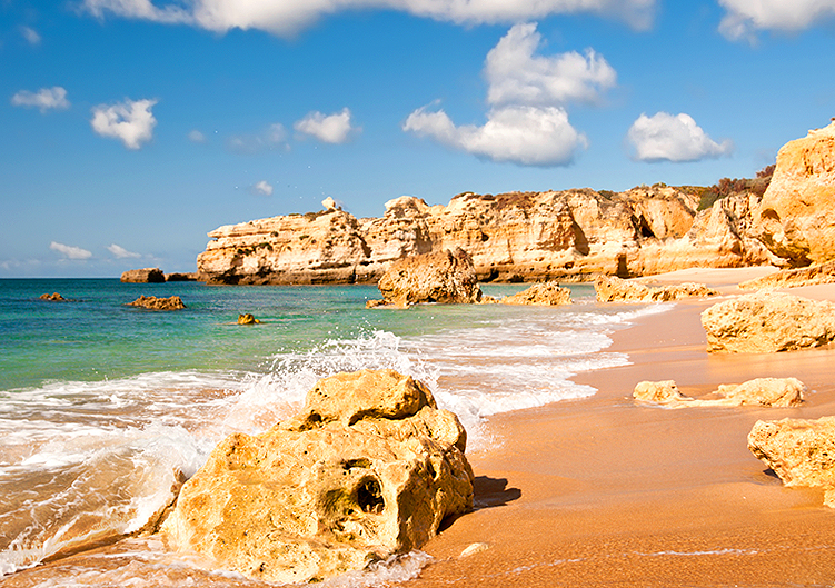 Bild på en strand med klippor i Faro, Portugal