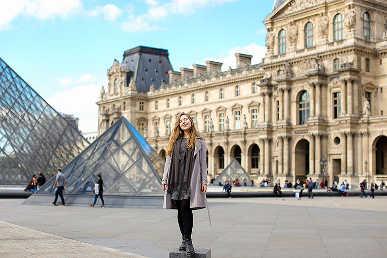 Bild på tjej framför Louvren i Paris