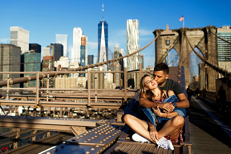 Bild på par som sitter på Brooklyn Bridge i New York