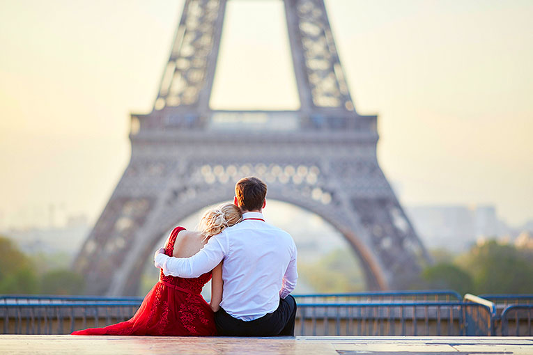Bild på par framför Eiffeltornet i Paris
