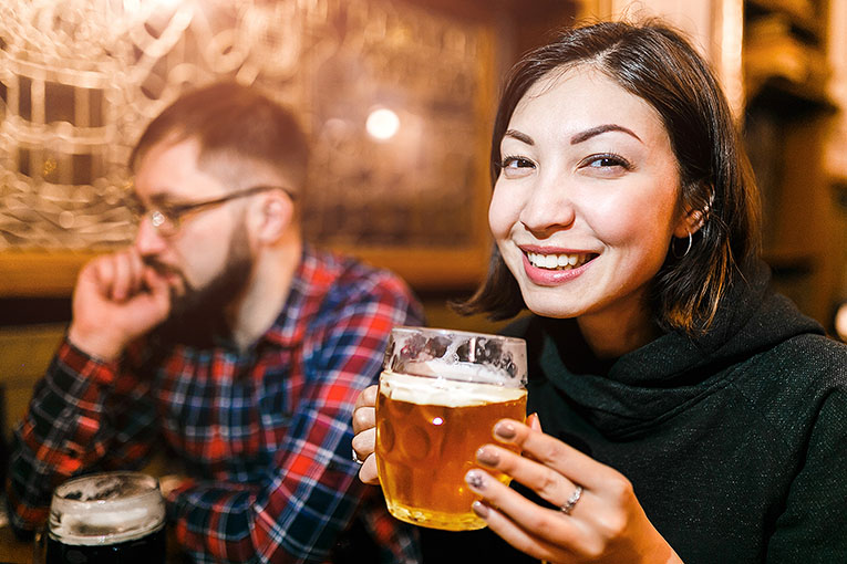 Bild på kvinna som dricker öl på en pub i Prag